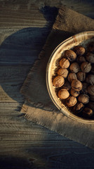 Red wild organic walnuts in basket and wood table