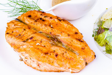 Grilled salmon steak with spices on white plate