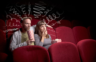 Naklejka premium Cute couple in cinema watching movie
