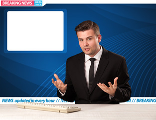 Television reporter telling breaking news at his studio desk with copy space