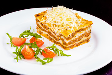 Traditional italian lasagna with beef meat and cheese on white plate