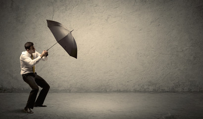 Handsome business man holding umbrella with copy space background