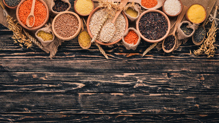 Set of Groats and Grains. Buckwheat, lentils, rice, millet, barley, corn, black rice. On a wooden  background. Top view. Copy space.