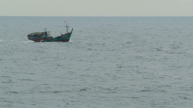 Small fisherman boat resists high waves during a storm