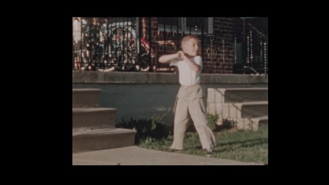 1956 Cute little boy with baseball bat swings at pitches