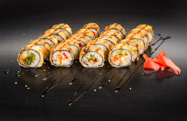 Sushi and roll set with seafood isolated on black wood background with reflection. Japanese cuisine.