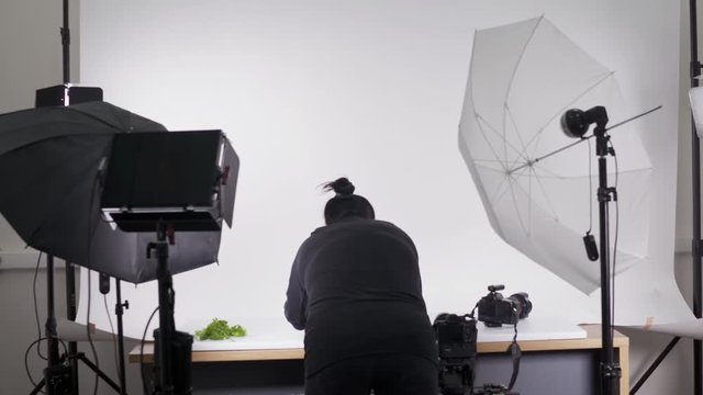 The process of food photography in photo studio. Woman photographer arranges food to create attractive still life pictures.