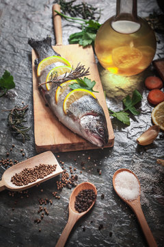 Salmon on rustic table with fresh ingredients for cooking
