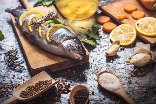 Salmon on rustic table with fresh ingredients for cooking