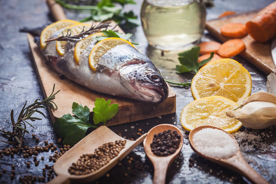 Salmon on rustic table with fresh ingredients for cooking