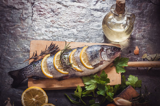 Salmon on rustic table with fresh ingredients for cooking
