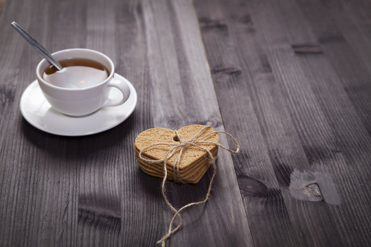 the White cup of tea and saucer on a brown wooden table. Copy space