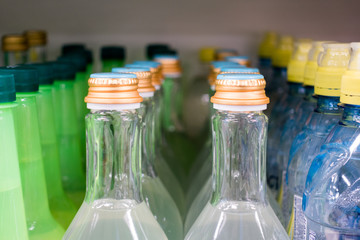 Lid plastic water bottle in the market. multi-colored plastic bottle caps