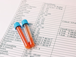 Hematology blood analysis report. Test tubes with blood lie on a blank with the results of tests