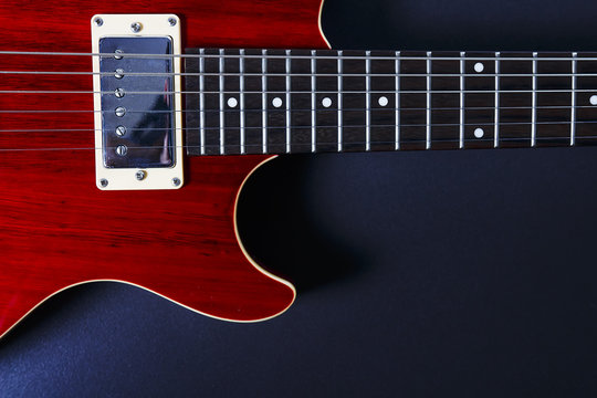Red electric guitar on black background closeup. Music concept.