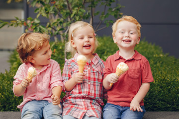 Group portrait of three white Caucasian cute adorable funny children toddlers sitting together sharing ice-cream food. Love friendship fun concept. Best friends forever.