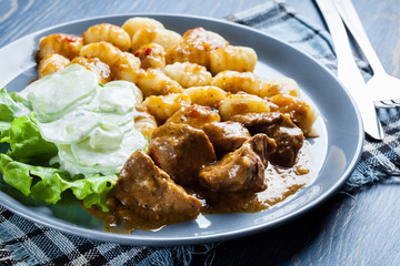 Italian potato dumplings with stew and cucumber salad