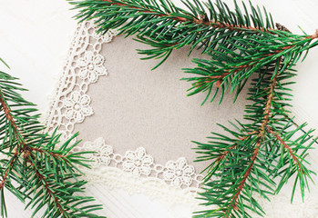 Fototapeta na wymiar Blank greeting paper card decorated lace ribbon and natural green fir tree boughs.