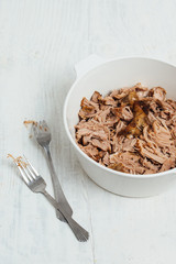 Traditional American Slow cooked Pulled pork made of boneless shoulder roast shredded with two forks cooked in crockpot or on bbq grill for Mexican Pork Carnitas, taco, tortillas or barbecue party
