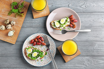 Composition with toasts, cheese and quail eggs on table