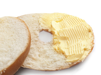 Tasty cut bun with butter on white background, closeup
