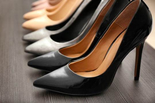 Elegant black shoes on wooden shelf, closeup