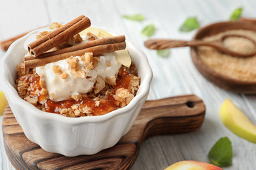 Ramekin with apple crisp on wooden board, closeup
