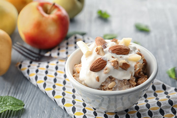 Bowl with apple crisp and ice cream on table
