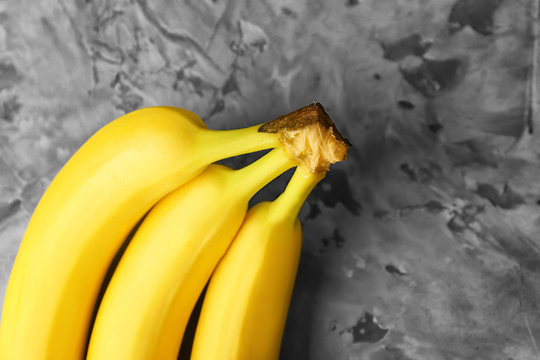 Tasty ripe bananas on grey background, closeup