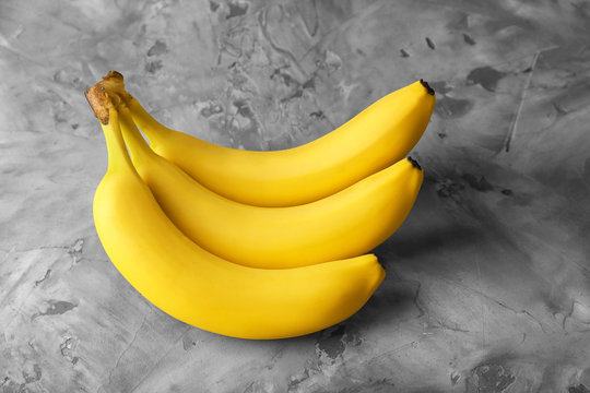 Tasty ripe bananas on grey background