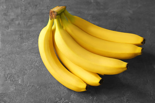 Tasty ripe bananas on grey background