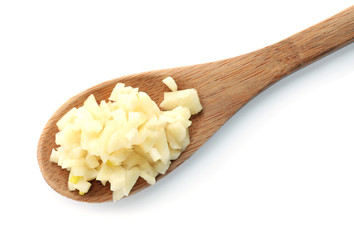 Wooden spoon with chopped garlic on white background