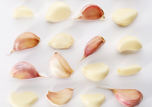 Composition with garlic cloves on white background