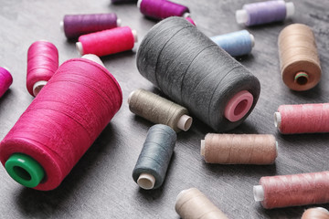 Set of color sewing threads on grey background
