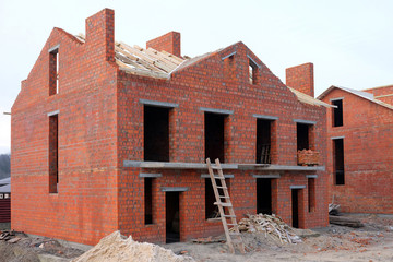 Unfinished brick house construction, still under construction. Unfinished roof under construction.