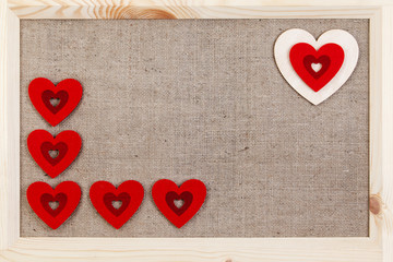 Heart on a wooden background covered with burlap, a card for Valentine's Day.