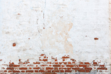 Texture of old brick wall with peeling plaster. Beautiful background of old brickwork of the historic building.