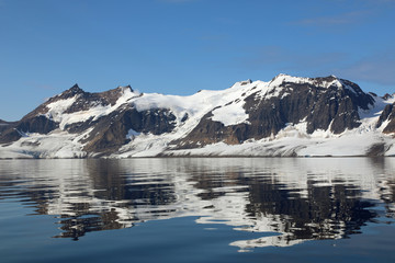 Fototapeta na wymiar Mountains reflection on ocean water surface