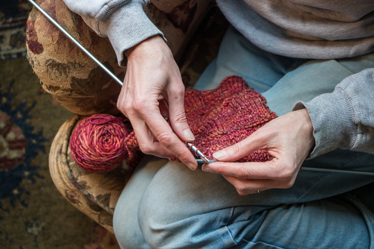 Woman knitting on an armchair