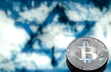 Bitcoin coins on the background of the Israeli flag, the concept of virtual money, close-up.