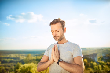 Serenity concept. Man praying or meditating outdoors