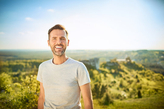 Portrait of man smiling at camera while on trip in the mountains