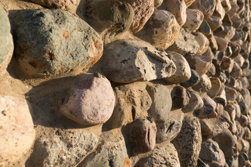 Cobblestone wall texture. Stone pattern. Round cobblestone. Background of stone wall.