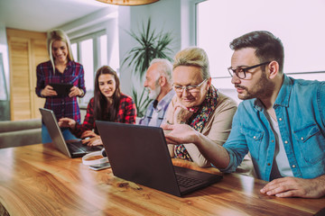 Young volunteers help senior people on the computer