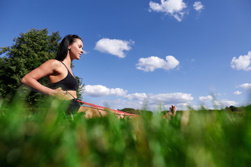 Sporty girl doing exercise with expander in the Park on the grass.