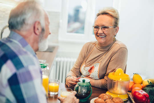 Elderly couple in the kitchen preparing breakfast