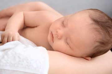Parent holding sleeping newborn, closeup