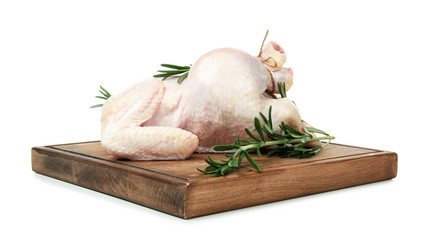 Wooden board with whole chicken and rosemary on white background