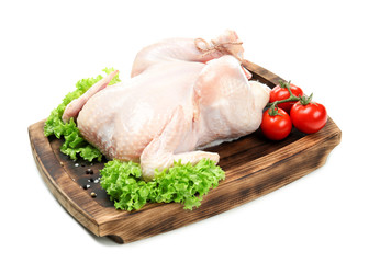 Wooden board with whole chicken, lettuce and tomatoes on white background