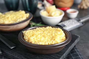 Dish with delicious risotto on wooden board